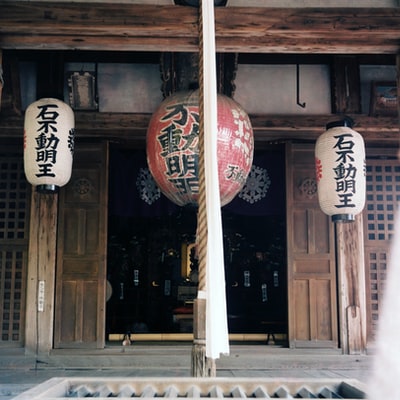 打开的门前挂着三盏印着汉字的红白灯笼